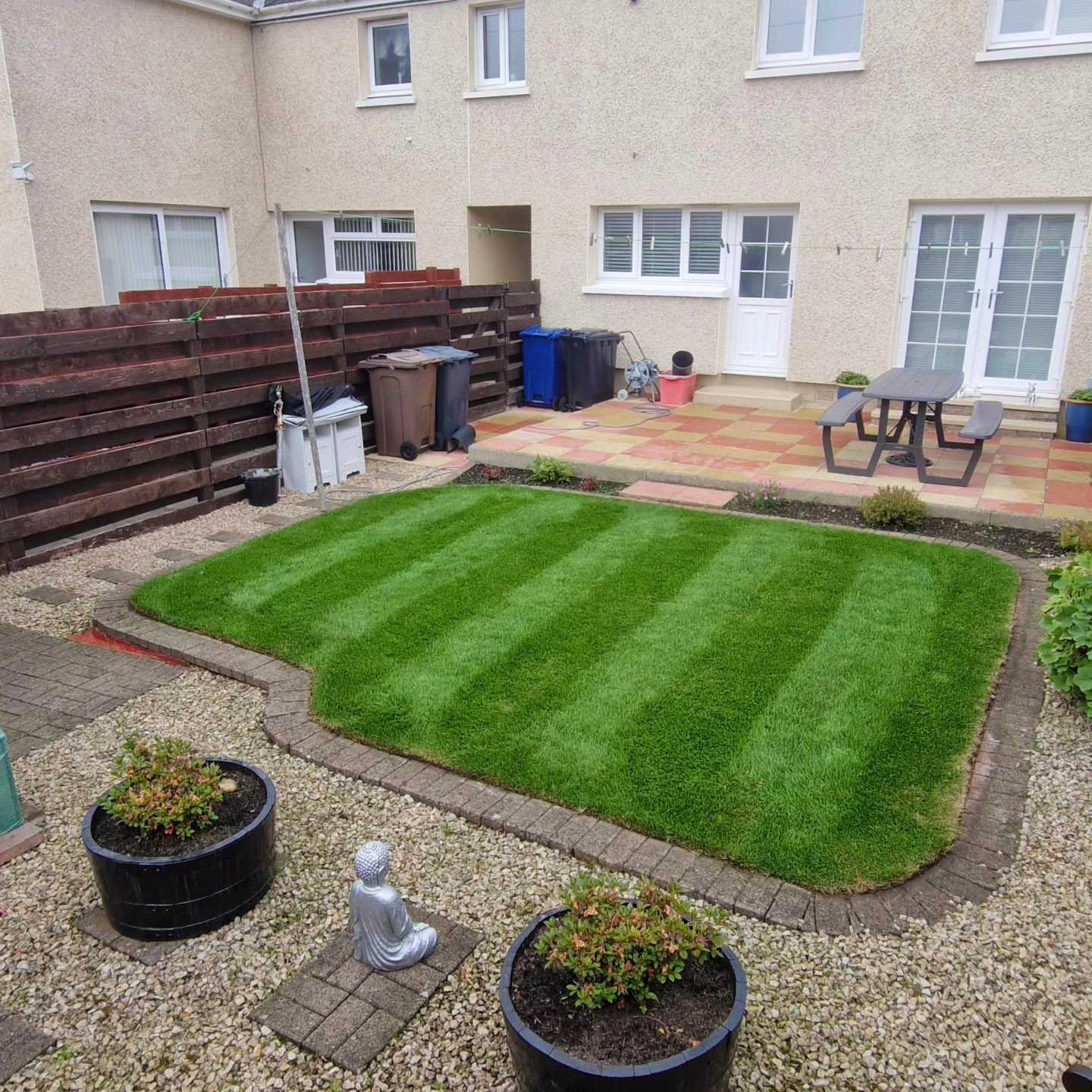 Striped lawn and tidy edges in a shared back garden