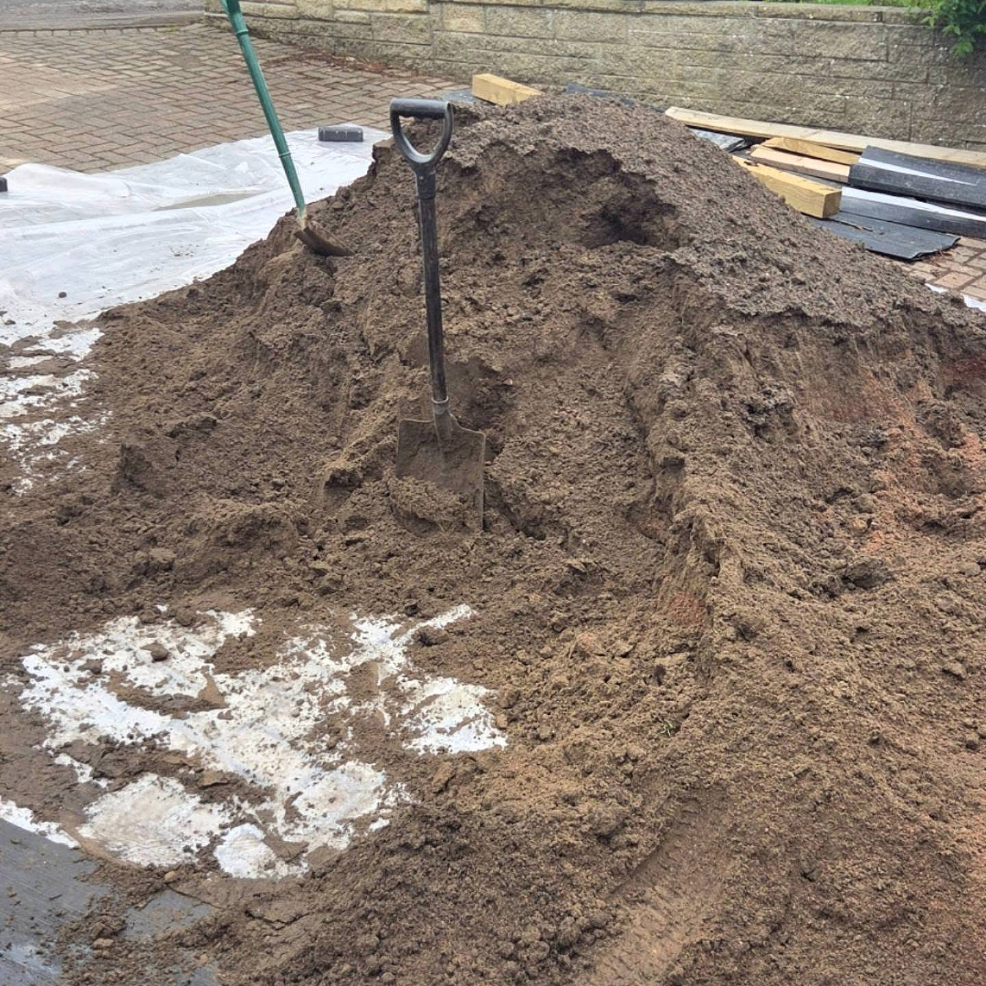 Pile of rootzone with a spade before spreading in an Eskbank garden