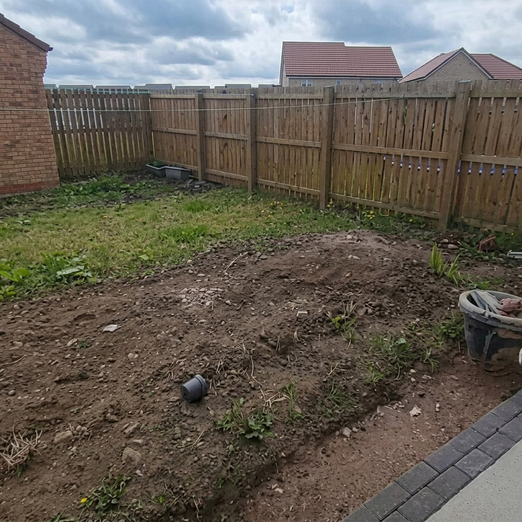 Weedy, uneven ground in an East Calder garden before turfing